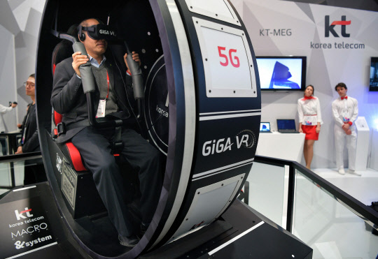 A visitor tests &quot;Korea VR Tour&quot; in the stand of KT -Korea Telecom- on the first day of the Mobile World Congress in Barcelonaon on February 27, 2017 in Barcelona.  Phone makers will seek to seduce new buyers with artificial intelligence functions and other innovations at the world's biggest mobile fair starting today in Spain.     / AFP PHOTO / LLUIS GENE
